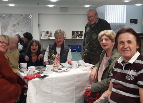 A group of people with tea and cake